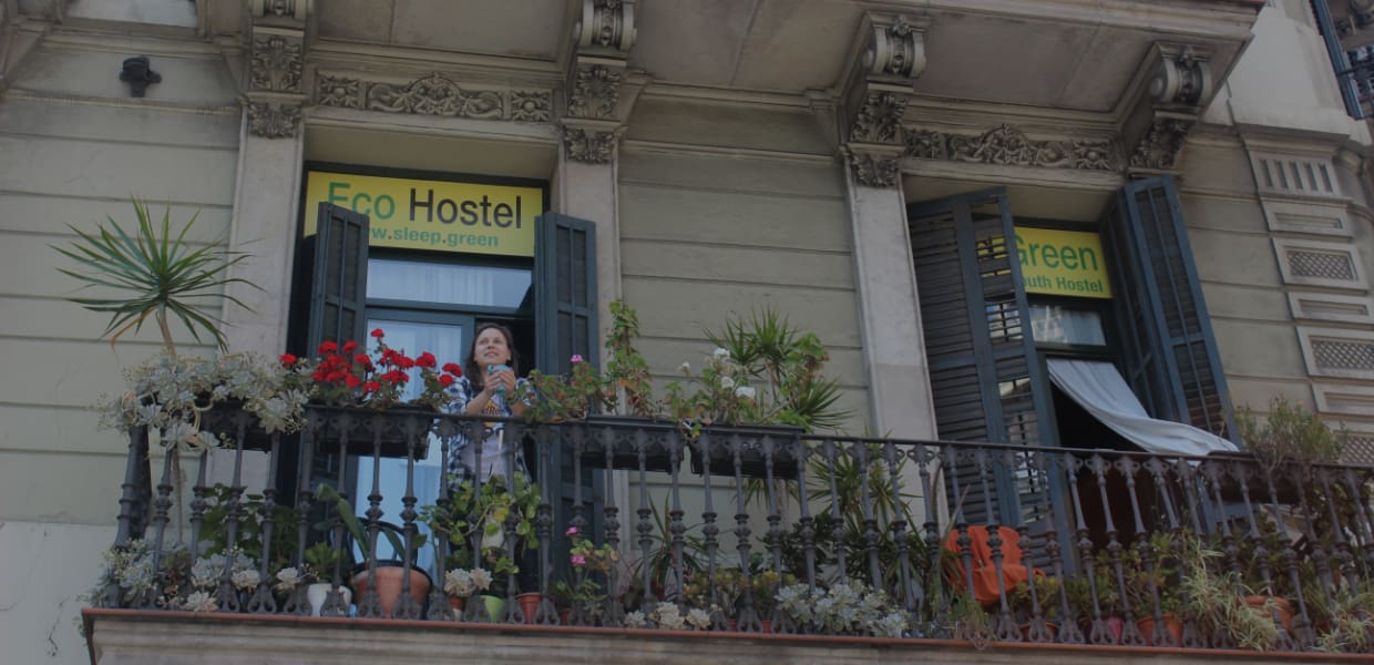 girl having coffee on the balcony of sleep green barcelona eco youth hostel